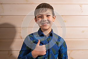 Portrait of a boy 8 years old brunette in a blue shirt. Laughs.