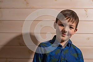 Portrait of a boy 8 years old brunette in a blue shirt. Smiling with closed lips