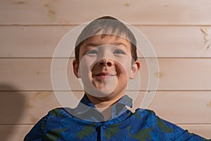 Portrait of a boy 8 years old brunette in a blue shirt. Smiling with closed lips