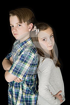 Portrait of boy with arms folded and girl with hands on her hips