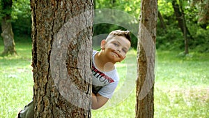 Portrait of a boy behind a tree
