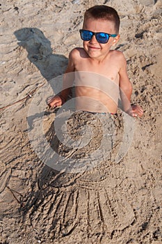 Portrait of a boy buried in sand