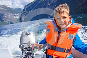 Portrait of boy close up driving the motorboat, Norway. He is enjoying the moment.
