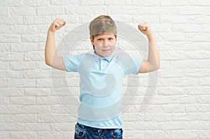 Portrait of a boy of European appearance on a light background, blond boy 9 years old. Funny strong child