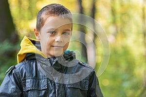 Portrait of boy in the forest smiling to the camera.