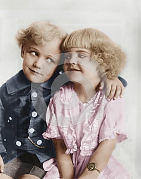 Portrait of a boy and girl with arm around her