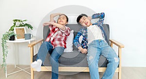 Portrait of boy and girl sitting on the soda in the living room. Relaxation and resting after school. Boy feeling sleepy and