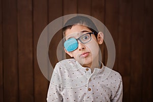 Portrait of boy in glasses with patch. Eye patch for glasses t treat lazy eye, amblyopia, strabismus.