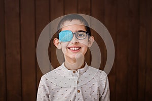 Portrait of boy in glasses with patch. Eye patch for glasses t treat lazy eye, amblyopia, strabismus.