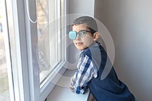 Portrait of boy in glasses with patch. Eye patch for glasses t treat lazy eye, amblyopia, strabismus
