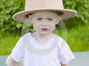 Portrait of a boy in a hat, outdoors in summer.