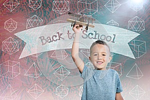 Composite image of portrait of boy holding toy airplane