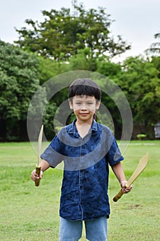 Portrait of a boy holding a wooden sword play.