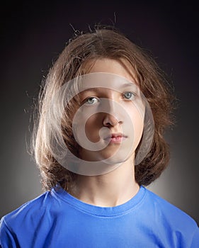 Portrait of a Boy with Long Hair in Blue Top