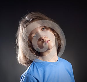 Portrait of a Boy with Long Hair in Blue Top