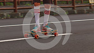 Portrait boy with a longboard on a beautiful road. Teenager skateboarding on city streets