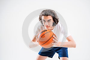 Portrait of a boy playing with a basketball on a white background