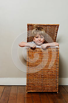 Portrait of a boy playing hide-and-seek game in wooden box