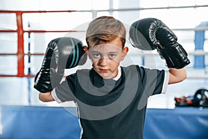 Portrait of boy that is practicing boxing in the gym with glowes on hands