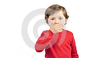 Portrait of a boy in a red sweater with his hands over his mouth