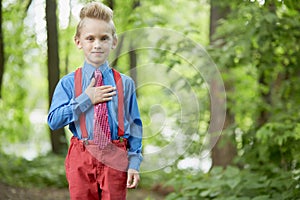 Portrait of boy in red trousers with braces and