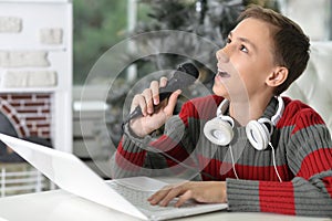 Portrait of a boy singing karaoke at home