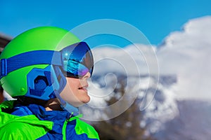 Portrait of a boy smile in ski helmet and mask over mountain