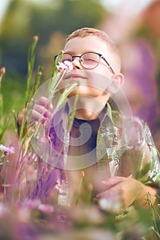 Portrait of a boy sniffing a wild flower close-up