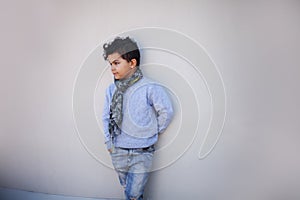 Portrait of a boy standing across the wall outdoors