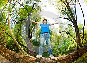 Portrait of boy standing on fallen tree stem