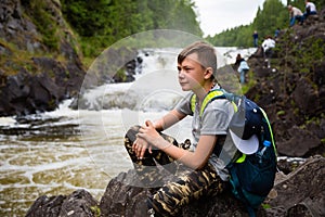 Portrait of a boy standing near a waterfall