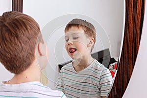 Portrait of a boy. He stands in front of the mirror and is done.