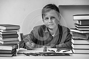Portrait of boy student doing homework. Black and white photo.