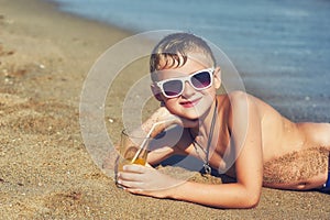 Portrait of a boy in sunglasses sunbathing at a seaside resort