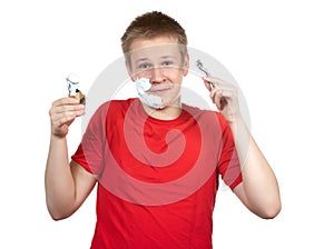 Portrait of the boy of the teenager in a red t-shirt with the razor and a small brush in hands