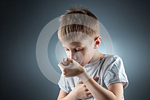 Portrait of a boy using an asthma inhaler to treat inflammatory diseases, shortness of breath. The concept of treatment for cough