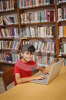 Portrait of boy using laptop in library