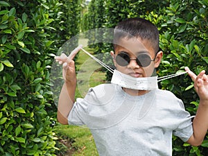 Portrait of a boy wearing black glasses And wearing a protective mask On a green background
