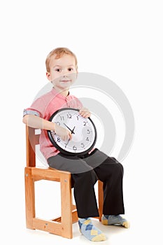 Portrait of boy wearing red. Kid holding big clock. Child back to school, isolated on white. Education and time concept.