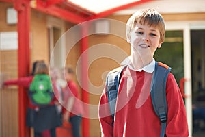 Portrait Of Boy Wearing Uniform Standing In School Playground