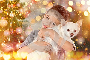 Portrait of boy with white dog beside Christmas tree. New year 2018. Holiday concept, Christmas, New year background.