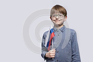 Portrait of boy withflag of Russia in hands on white background. Education in Russia. Training in Russian Federation