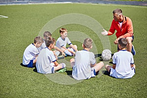 Coach Instructing Football Team in Field