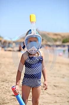 Portrait of a brave caucasian girl at the seaside wearing diving mask