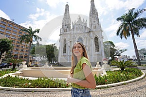 Portrait of Brazilian young traveler woman visiting the city of Victoria with its Cathedral on the background, Espirito Santo,