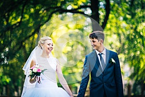 Portrait the bride and groom on the background of the park alley