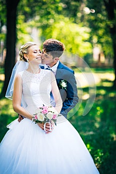 Portrait the bride and groom on the background of the park alley