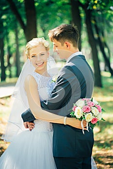 Portrait the bride and groom on the background of the park alley