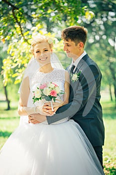 Portrait the bride and groom on the background of the park alley