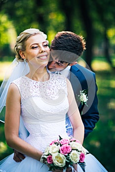 Portrait the bride and groom on the background of the park alley